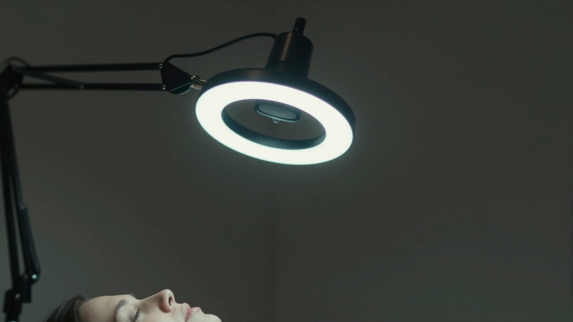 Lampa diagnostyczna skierowana na twarz podczas badania skóry